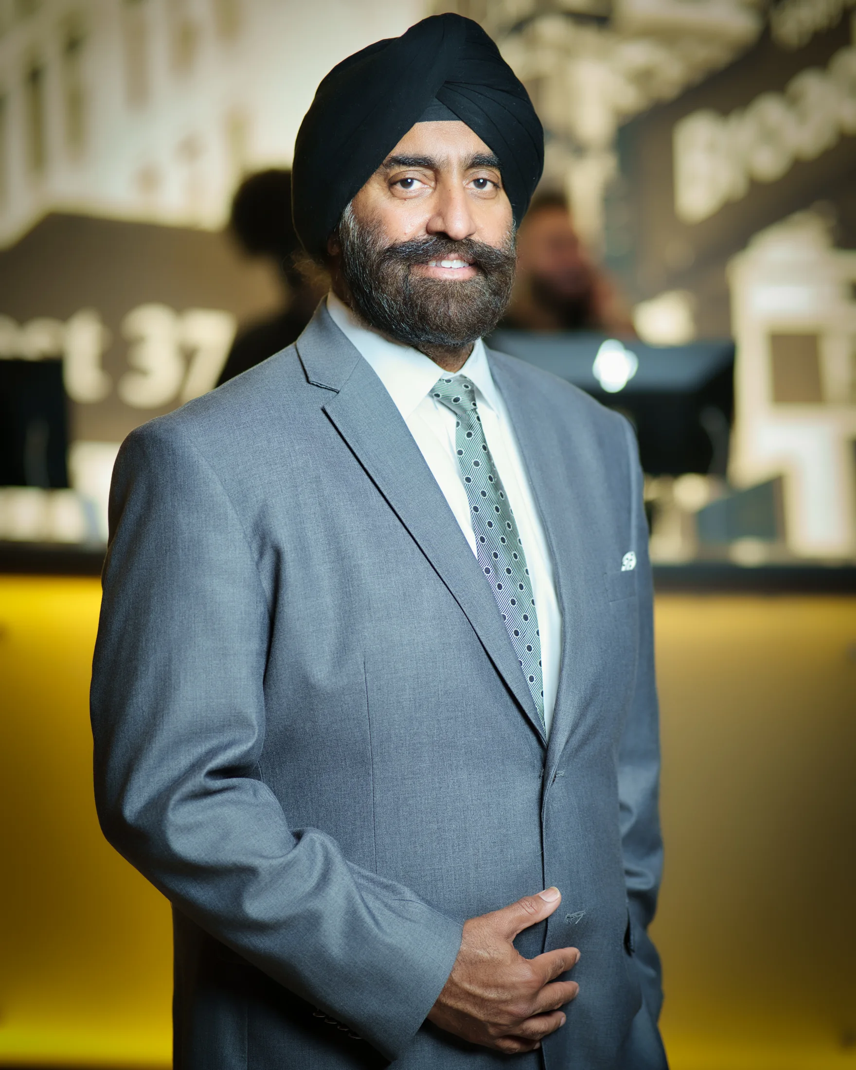 Dr. Jasdip Singh Jesse in a formal grey suit